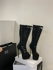 Detailed side view of black cutout stiletto Roman boots with high platform and open toe