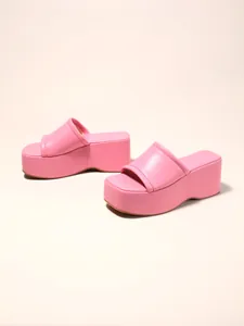 Detailed side view of pink platform wedge sandals showing thick sole and soft upper.