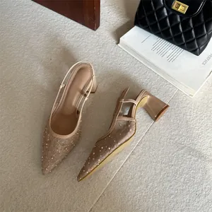 Vista superior de elegantes tacones destalonados de encaje beige con las perlas