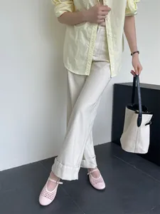 Ballerine Mary Jane rosa intrecciate e traforate indossate con pantaloni casual beige.