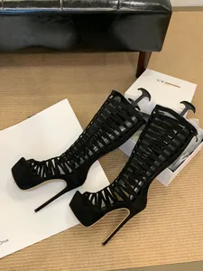 Close-up of black suede cutout platform stiletto gladiator boots with high heels.