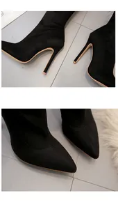 Detailed close-up of black suede over-the-knee boots with elegant high stiletto heels
