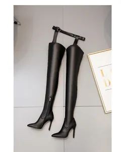 Sexy black pointed over-the-knee boots with unique belt attachment and high stiletto heels.