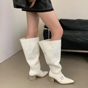 Detailed side view of white slouchy western cowboy boots with pointed toe and block heel