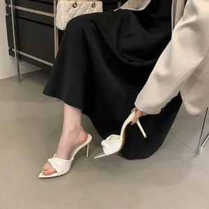 Elegante weiße Pantoletten mit Pfennigabsatz, spitzer Zehenpartie und Knotendetail.