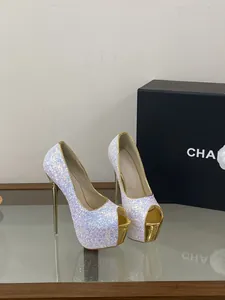 Detail view of white glitter peep-toe pumps featuring gold platform and high heels