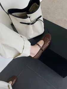 Vista ravvicinata di scarpe Mary Jane intrecciate marroni con design traforato alla moda.