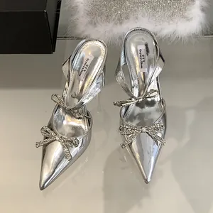 Elegant silver pointed-toe high heels with rhinestone bow and slingback design