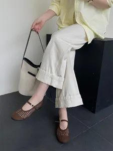 Dettaglio delle scarpe Mary Jane marroni intrecciate indossate con outfit estivo