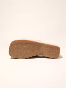 Detailed close-up showing the non-slip textured sole of beige platform wedge slides for women