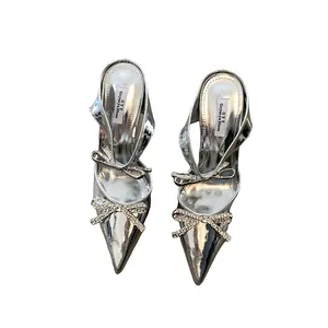 Silver pointed toe high heel sandals featuring sparkling rhinestone bow embellishments