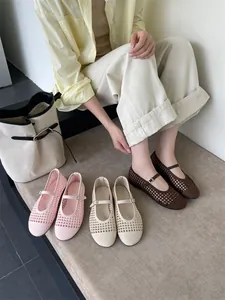 Dettaglio di scarpe Mary Jane intrecciate nei colori rosa, crema e marrone.