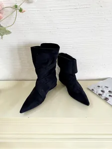 Detail showing the elegant pointed toe and slouchy black suede of these ankle boots