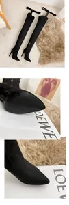 Detailed view of sexy black suede over-the-knee boots featuring sharp pointed toes and stiletto heels