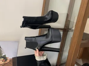 Detailed side view of black platform Chelsea boots featuring 16cm high chunky heels