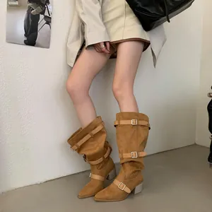 Stylish tan suede slouchy boots featuring pointed toe, decorative buckles, and chunky heels