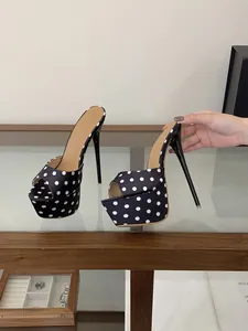 Gros plan de mules à pois de style français avec plateforme et talons aiguilles fins.