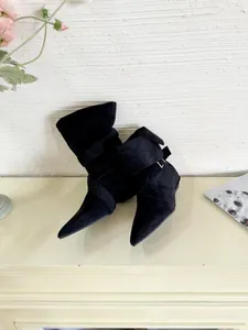 Detailed side view of elegant black pointed-toe suede boots with buckle strap details