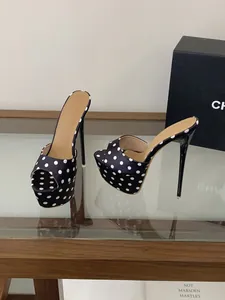 Vue détaillée d'élégantes mules à plateforme à pois noirs et blancs avec talons aiguilles.