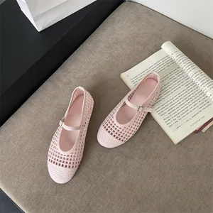 Ballerine Mary Jane rosa intrecciate e traforate con cinturino a fibbia su superficie.