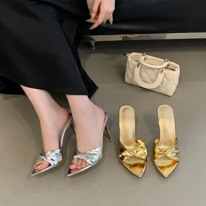 Elegant pointed-toe stiletto mules with twisted knot design in metallic silver and gold.