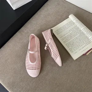 Scarpe Mary Jane intrecciate rosa con design traforato, abbinate a un libro d'epoca