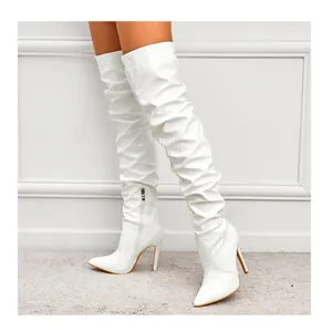 Vue détaillée de bottes blanches au-dessus du genou en cuir verni à talons aiguilles