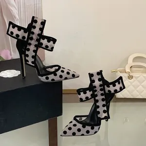 Detailaufnahme von gepunkteten Mesh-Stilettos mit eleganter Schleife und spitzer Kappe.