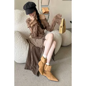 Stylish tan suede pointed-toe ankle boots with low chunky heel and buckle detail on model