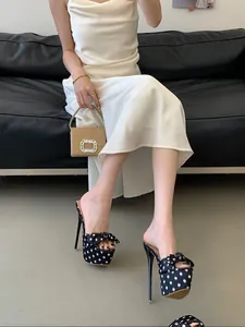Elegante primer plano de sandalias de tacón alto con lunares y lazo en el modelo.