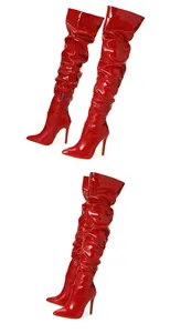 Gros plan sur bottes cuissardes rouges en similicuir verni à talon aiguille et plissé