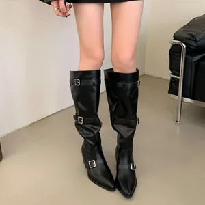 Close-up of black pointed-toe slouchy knee-high boots with stylish buckle strap details