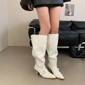 Elegant white pointed-toe slouched cowboy boots with thick heels and buckle detail