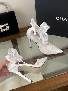 Detailansicht weißer Stöckelschuhe mit Blumen-Spitze und Knöchelriemen-Schleife
