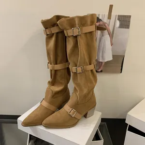 Detailed view of tan slouchy western cowboy boots featuring pointed toe and buckle straps