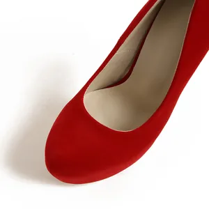 Primer plano de tacones rojos de ante con punta redonda y textura elegante y suave.