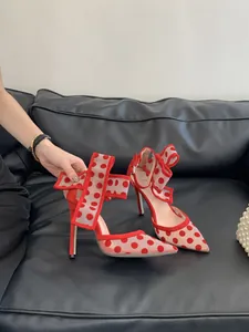 Detailansicht eleganter High Heels aus rotem gepunktetem Netzgewebe mit schicken Schleifen