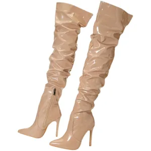 Bottes cuissardes élégantes en cuir verni nude avec bout pointu et talons aiguilles.