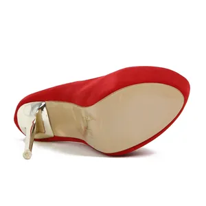 Vista detallada de zapatos stiletto de plataforma roja con tacón dorado y suela beige.
