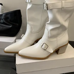 Detailed side view of white western boots featuring pointed toes and silver buckle straps.