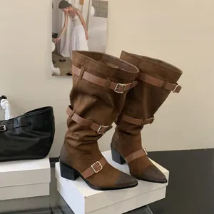 Slouchy brown suede western boots with multiple buckle straps and a pointed toe