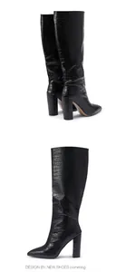 Detailed view of black crocodile embossed knee-high boots with pointed toe and chunky heel.