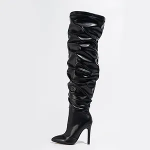 Detailed side view of black over-the-knee stiletto boots with slouchy ruched texture