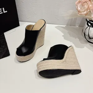 Détail de mules compensées en cuir noir avec talon compensé en corde