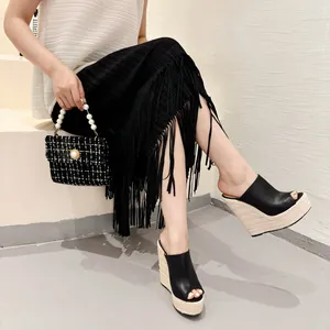 Mules compensées élégantes en cuir noir avec semelle en corde portées par un mannequin