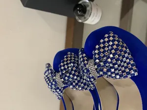 Detail of royal blue platform pumps featuring glittering rhinestone bow decorations