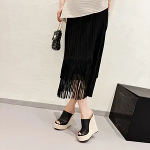 Sandales compensées noires à bout ouvert avec plateforme en corde sur un mannequin.