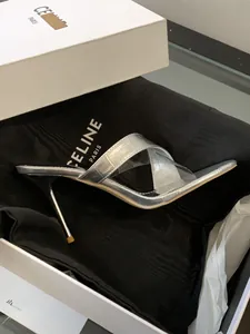 Nahaufnahme von silbernen High Heels mit Krokodilmuster und transparenten Kreuzriemen