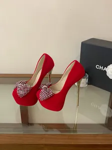 Detailed view of red platform high heels with luxury rhinestone bow and gold stiletto.