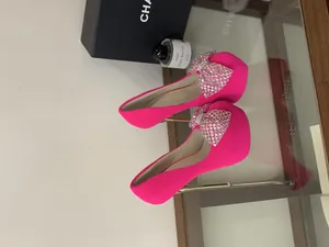 Fuchsia pink platform high heels with sparkling rhinestone bow and thin stiletto.